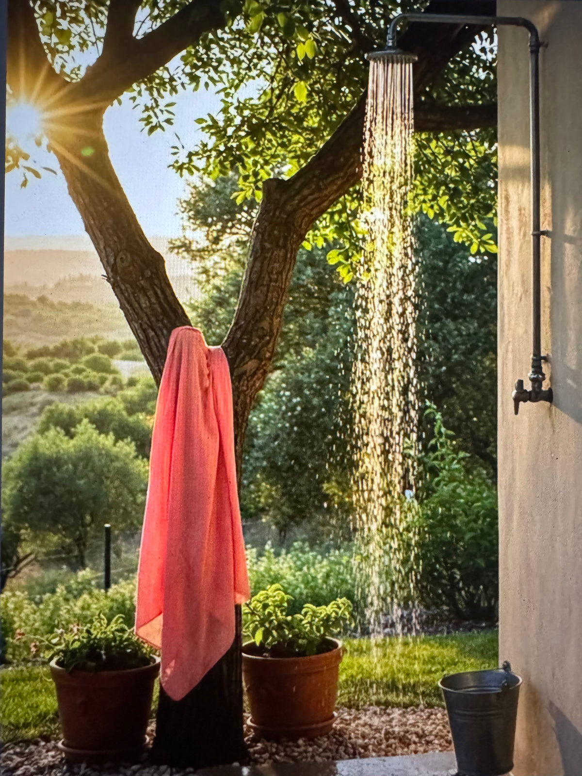 Coral sarong hanging beside an outdoor garden shower in Maui